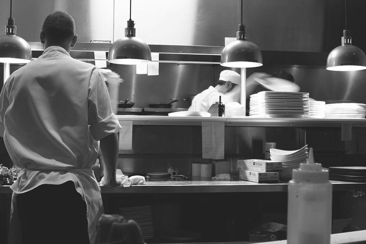 person in kitchen in black and white